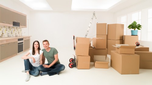 Removal staff using PPE while lifting furniture during a move