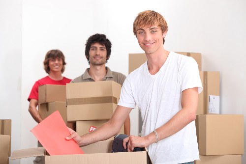 Professional movers loading furniture into a Belgravia removal van